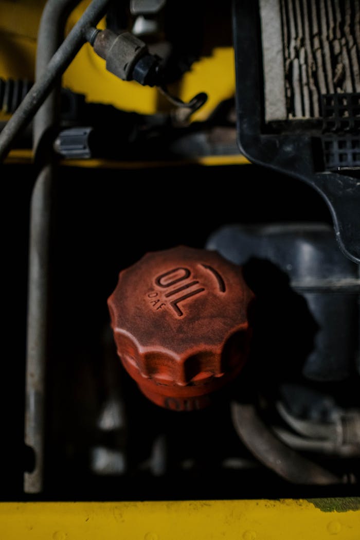 Detailed view of a red oil cap on machinery, emphasizing industrial design.
